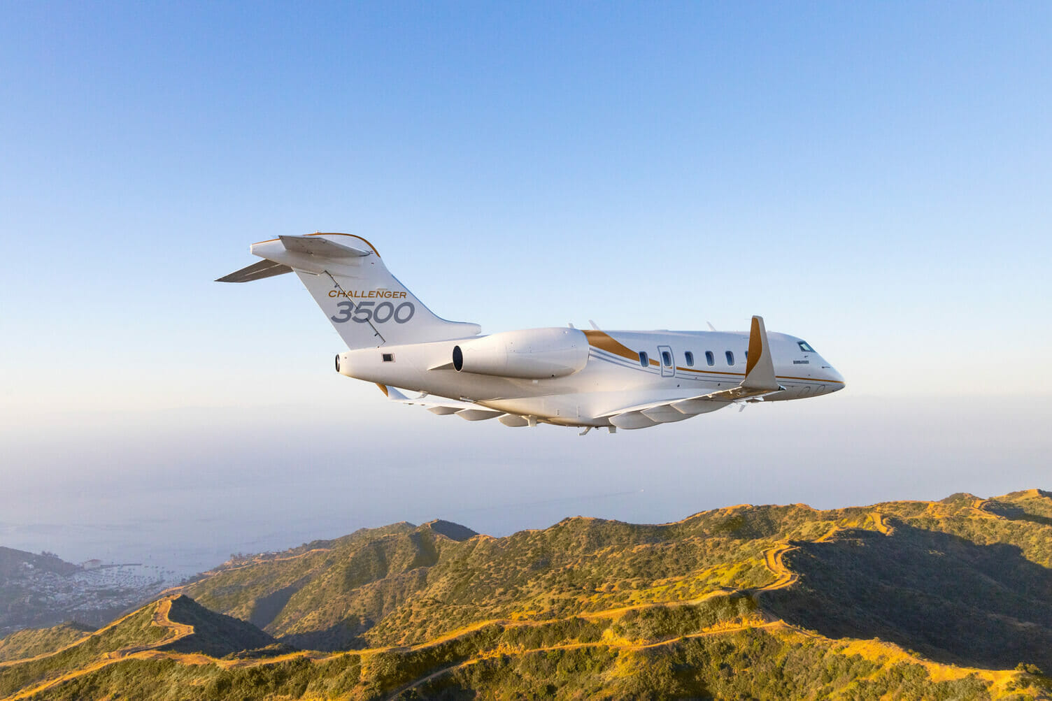 Bombardier Challenger 3500 Exterior during sunset flying over mountains - private jet charter safety ratings
