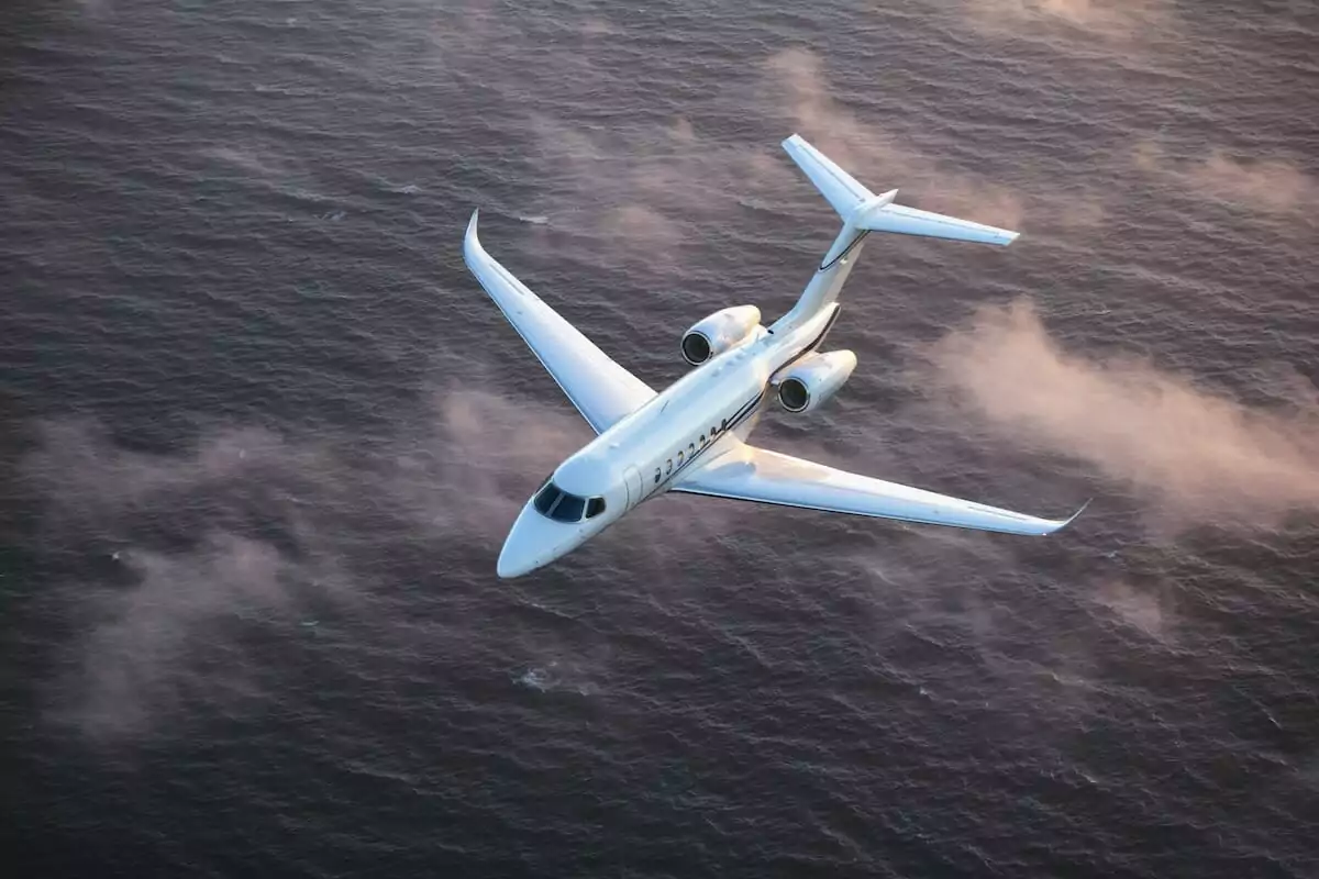 Cessna Citation Longitude Exterior white flying abouve the sea and clouds