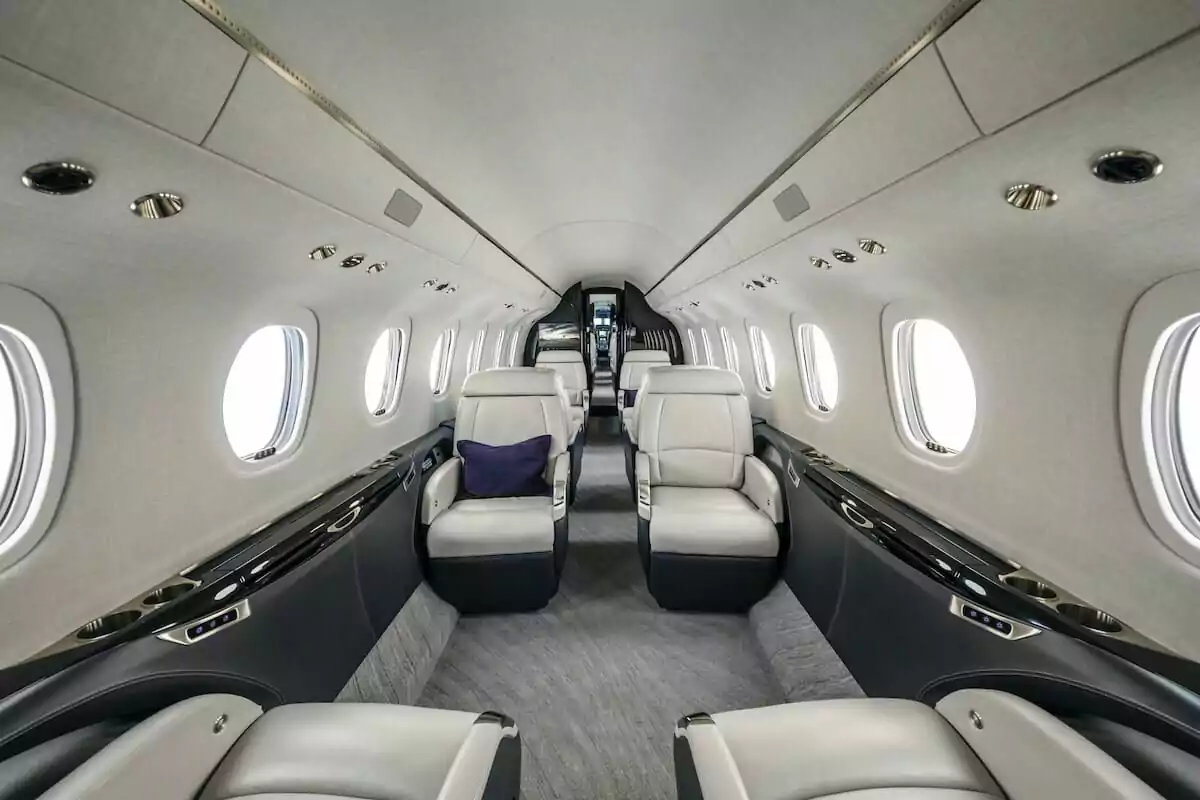 Cessna Citation Longitude Interior white leather seats with purple cushion from back of aircraft looking forward