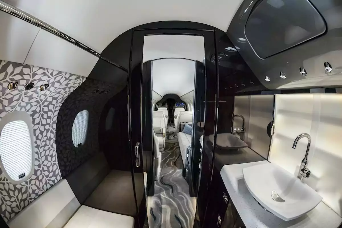Cessna Citation Longitude Binne-waskamer aan die agterkant van die vliegtuig, vorentoe, wasbak en toilet in sig