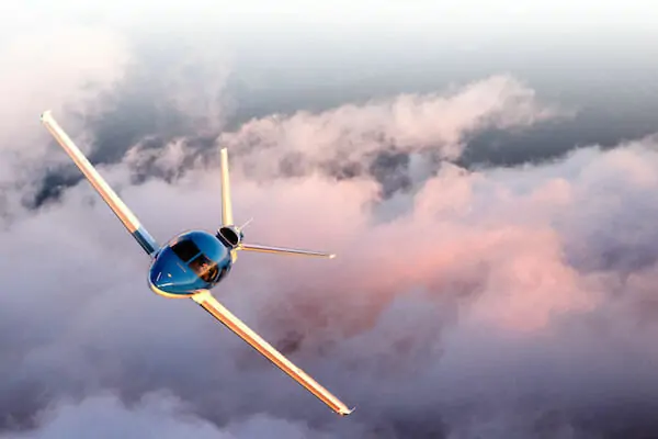 Cirrus Vision Jet SF50 Zunanji zračni posnetek, ki leti skozi oblake v modri barvi