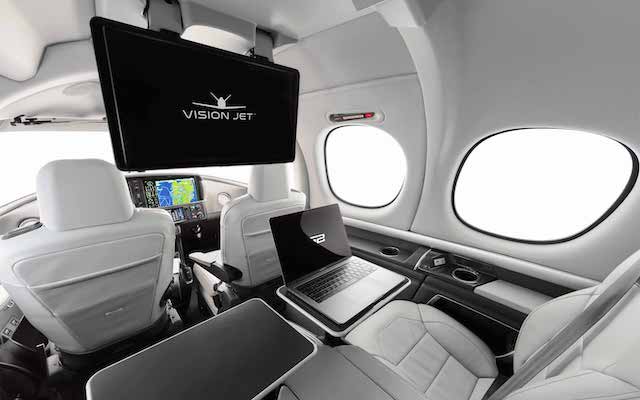 Ponto de vista da configuração de dois assentos do interior do Cirrus Vision Jet SF50 dos assentos traseiros com o monitor para baixo