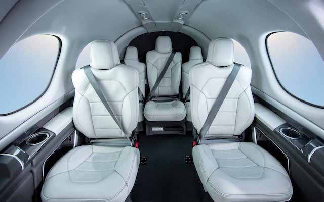 Interior Cirrus Vision Jet SF50 voltado para a cabine com configuração de cinco assentos em couro branco