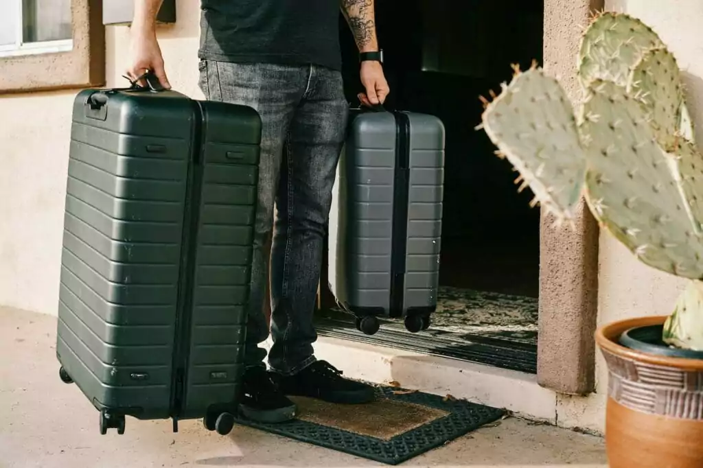 Max con dos maletas y bolsos.