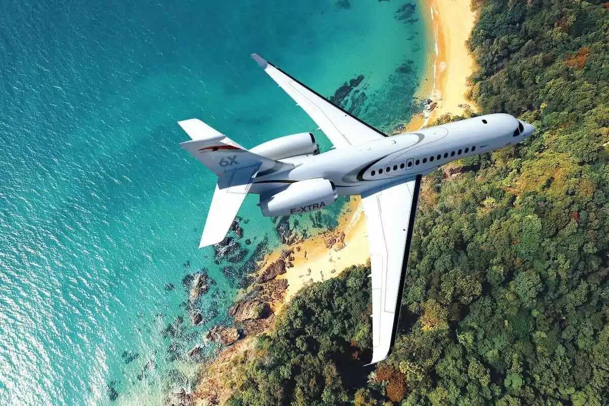 Falcon 6X exterior overhead view over ocean - type of private jet
