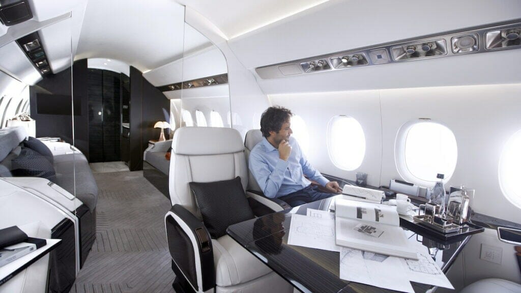Človek sedi in gleda skozi okno Dassault Falcon 6X