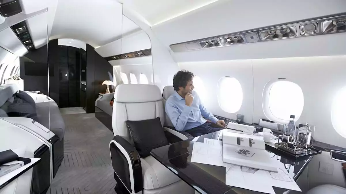 Man sitting looking out window of Dassault Falcon 6X on a last-minute charter flight