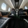 Embraer Phenom 300E interior low down shot of cabin during flight with blue interior