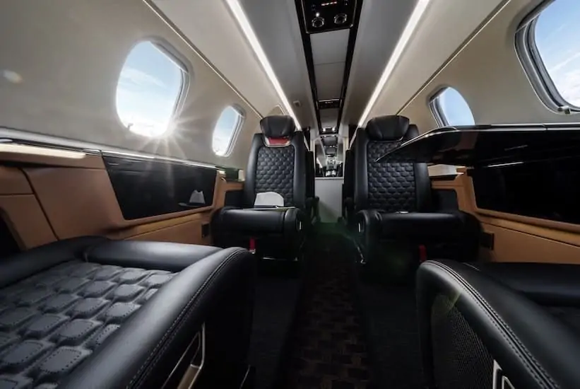 Embraer Phenom 300E interior low down shot of cabin during flight with blue interior