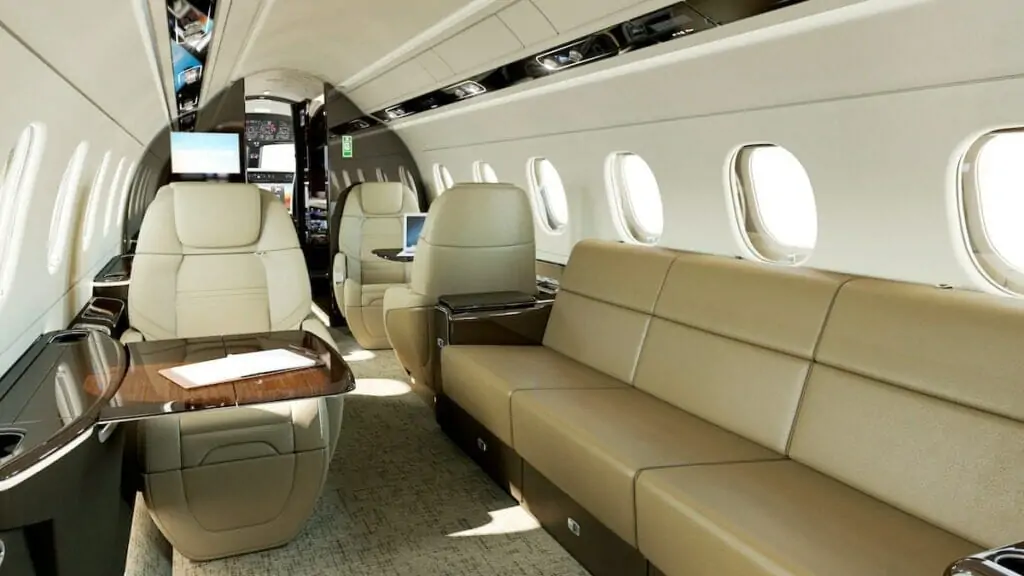 Embraer legacy 500 binneruim met stoele van roomkleurige leer, sien uit na die kajuit