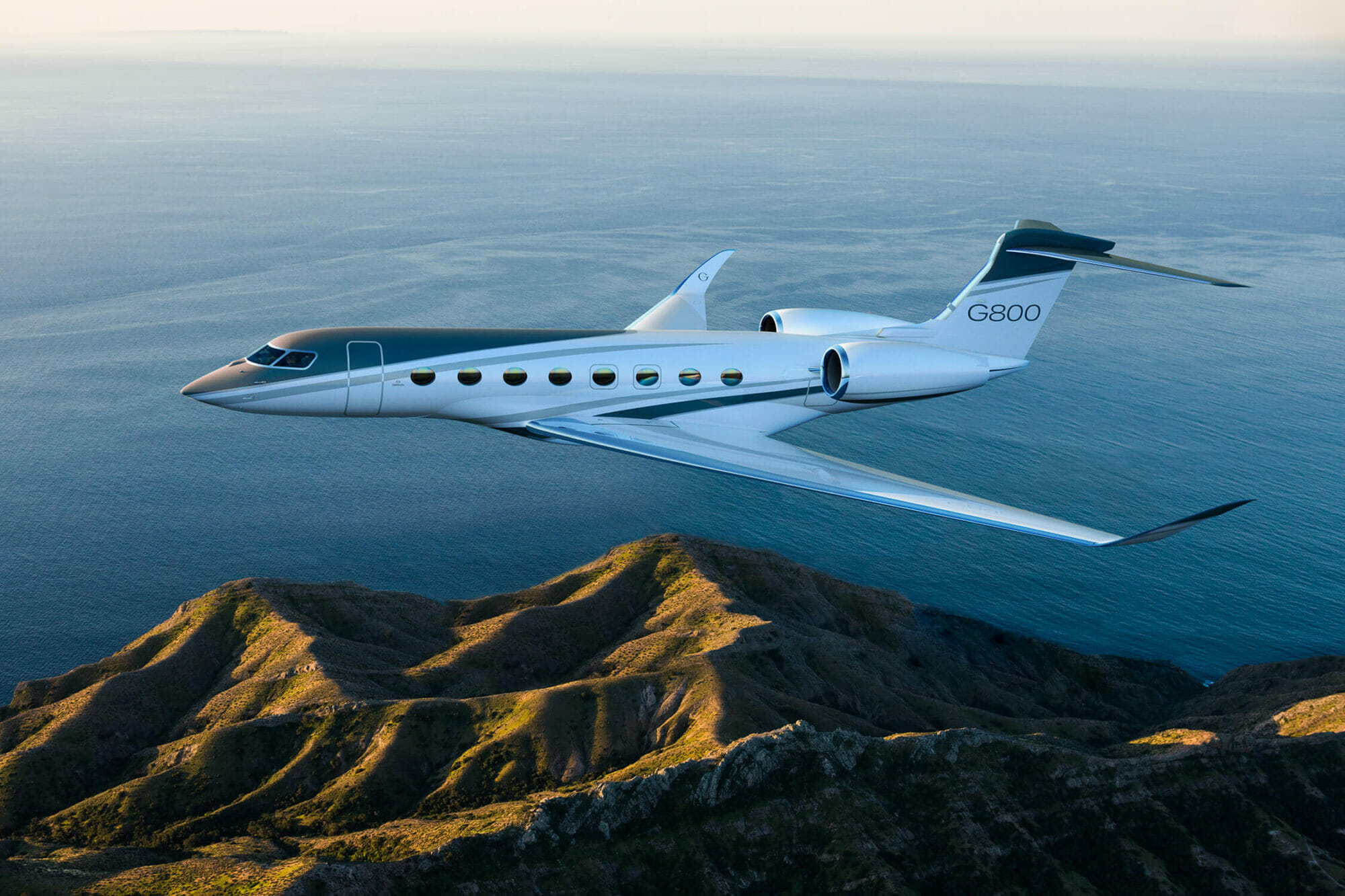 Gulfstream G800 exterior aerial shot cruising above mountains and water
