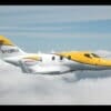 Yellow Hondajet side profile N420AH flying above clouds