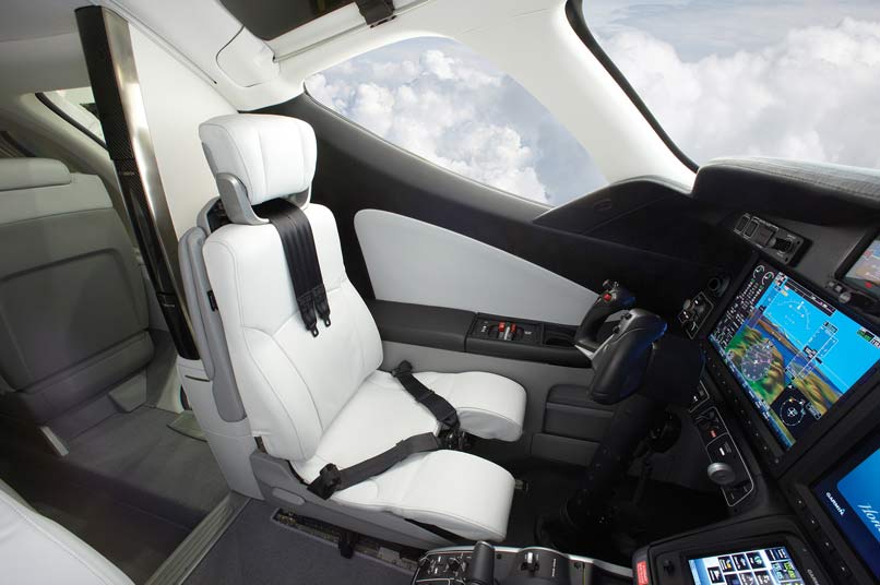 HondaJet cockpit captains seat trimmed in white leather with clouds in the background