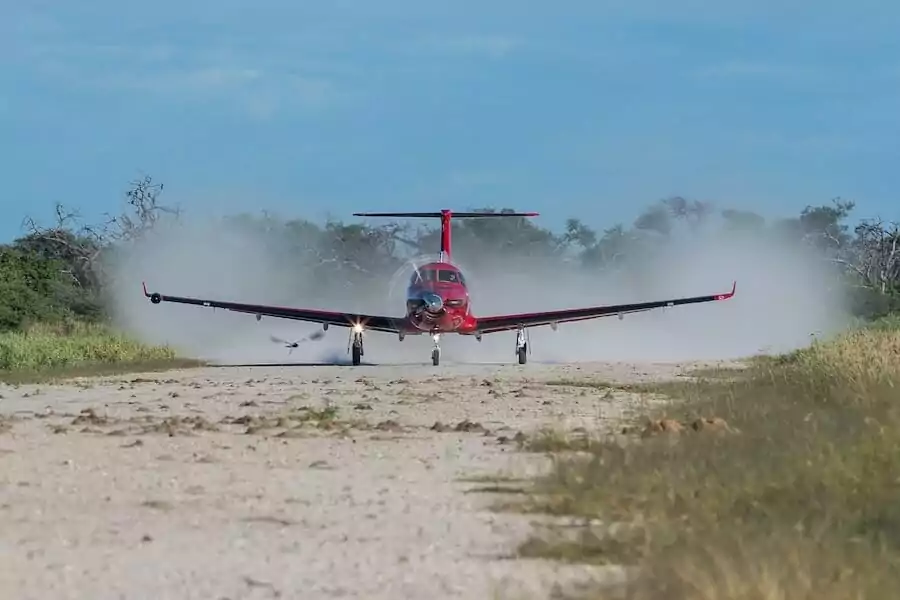 Pilatus PC-12 rooi landing op vuil aanloopbaan