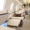 Pilatus PC-24 Interior with cream leather seats, brown cushions and suitcases in the background