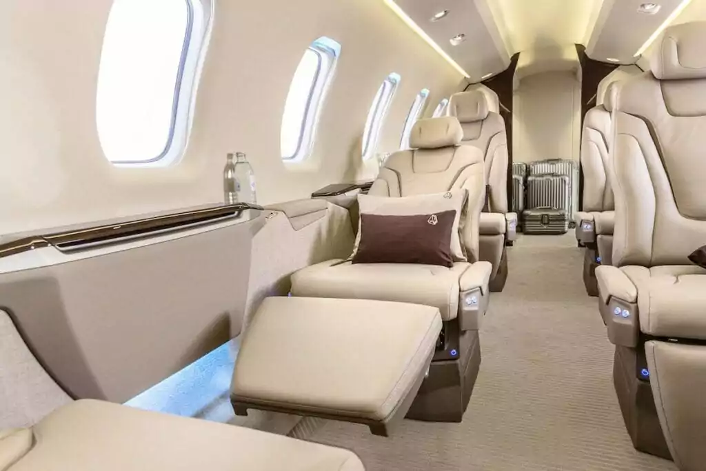 Pilatus PC-24 Interior with cream leather seats, brown cushions and suitcases in the background