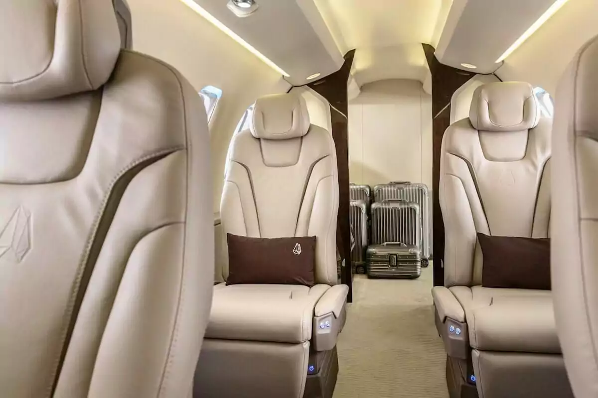 Pilatus PC-24 Interior with cream leather seats and brown cushions, silver suitcases in the background