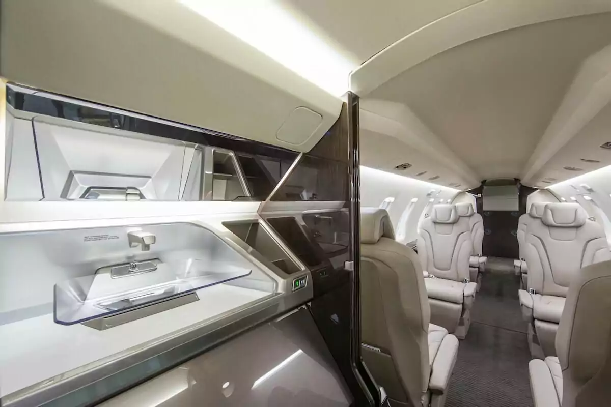 Pilatus PC-24 Interior sink in the galley, white leather seats and brown wood trim