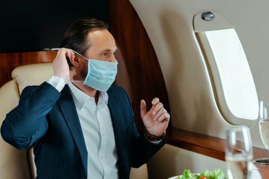 Човек, свалящ маска за лице на частен самолет