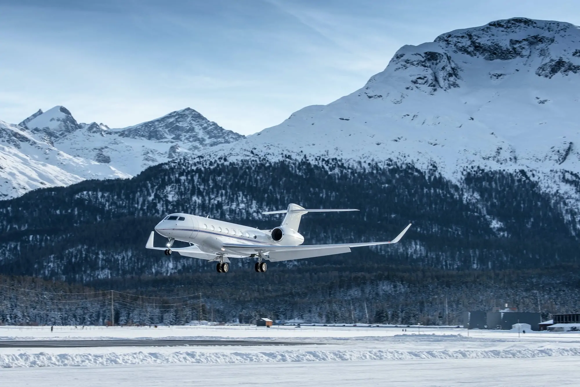 Jet de negocios aterrizando en un aeródromo en las montañas de Suiza. Gestión de jets privados. Un hermoso paisaje de montaña al fondo.