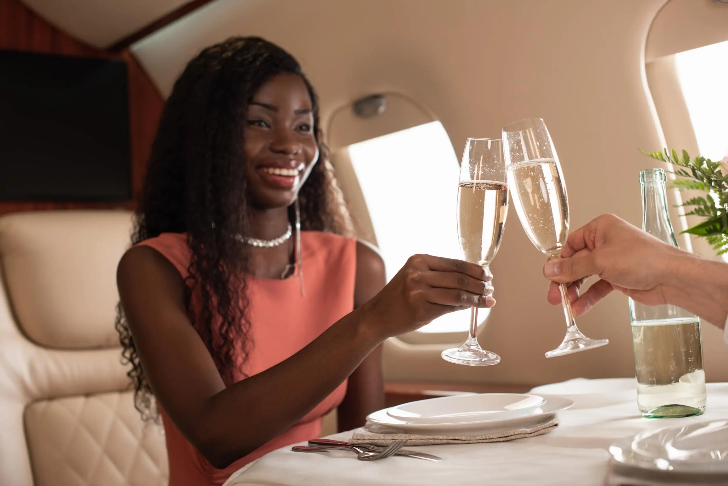 Woman on private jet clinking champagne glasses