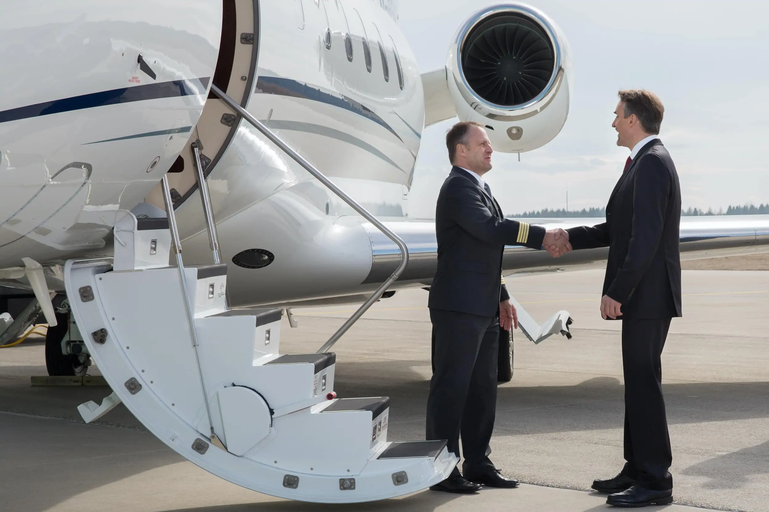 Private jet lease handshake on tarmac