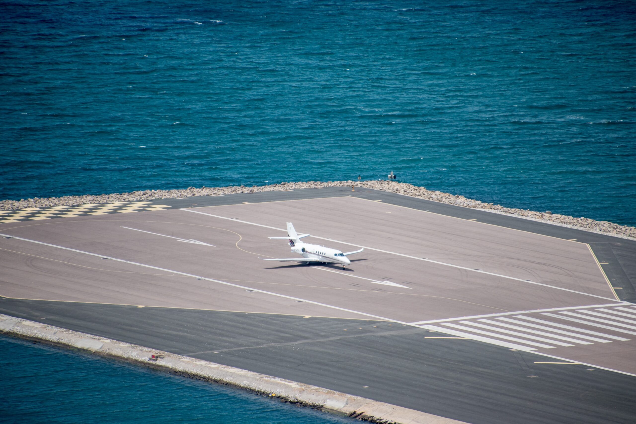 Un privato Cessna Citation business jet in procinto di decollare dall'aeroporto di Gibilterra, con il mare visibile sullo sfondo