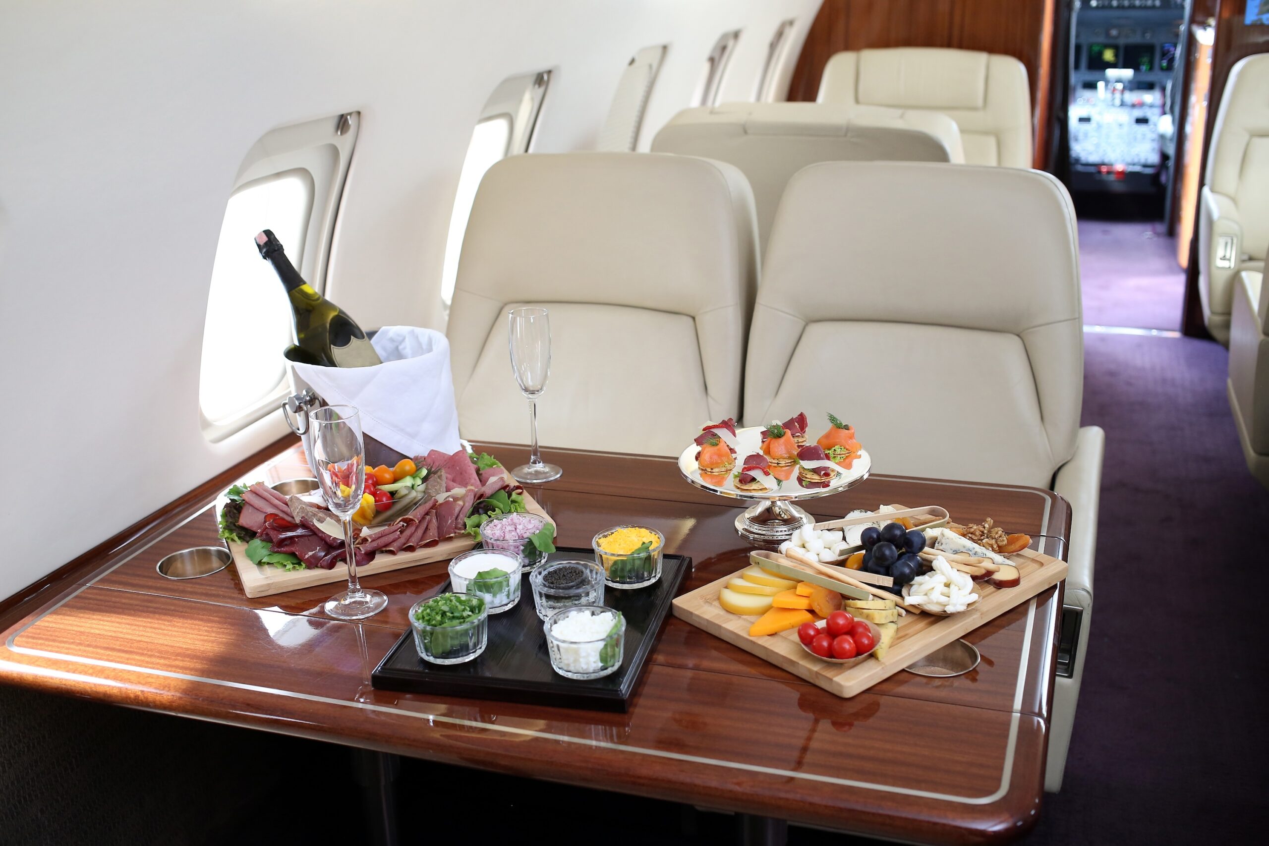 Selezione di cibo e champagne sul tavolo nel jet privato - jet privato vs prima classe