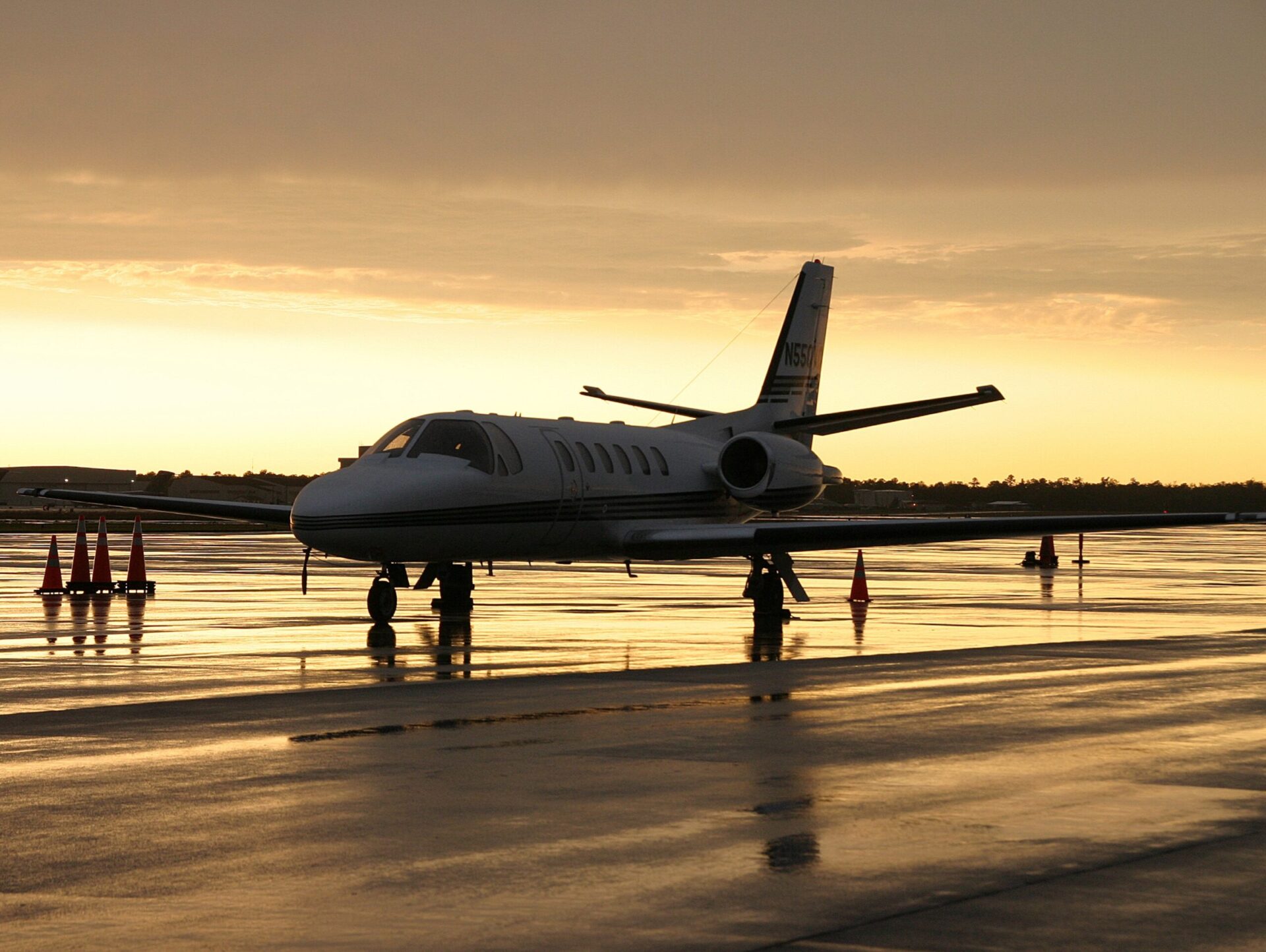 Cessna Citation 我停在风雨肆虐的坡道上，身后是金色的天空